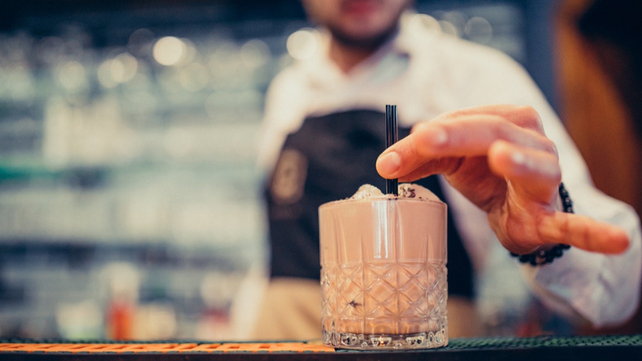 Barman przygotowuje drink przy barze